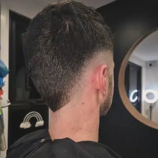 Boys skin fade in barber chair, rear view